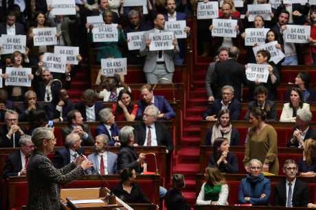左翼议员对刚抵达国会的女总理博尔内(左)报以嘘声，并举起标语抗议。路透社