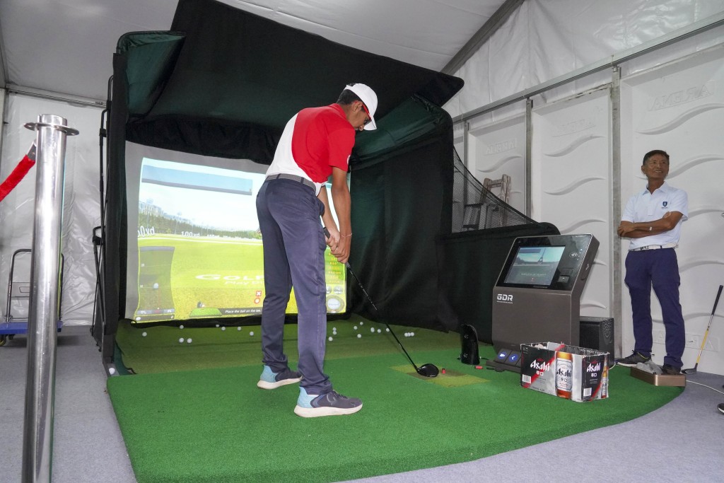  为支持高球普及化的工作，香港哥尔夫球会在场设高球模拟练习器，让不同年龄人士可以一试挥杆，当日高球模拟练习器一直排长龙，足见高球是一项非常有魅力的运动。（摄：陈极彰）