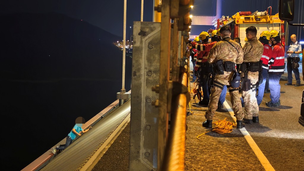青馬大橋的士男乘客跳車 再翻欄危坐橋邊 與警方消防對峙。黃文威攝