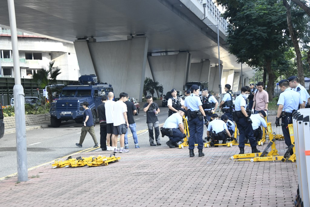  多名穿上戰術背心的警員於法院對開行人路增設鐵欄和防止車輛衝擊的設備。 楊偉亨攝