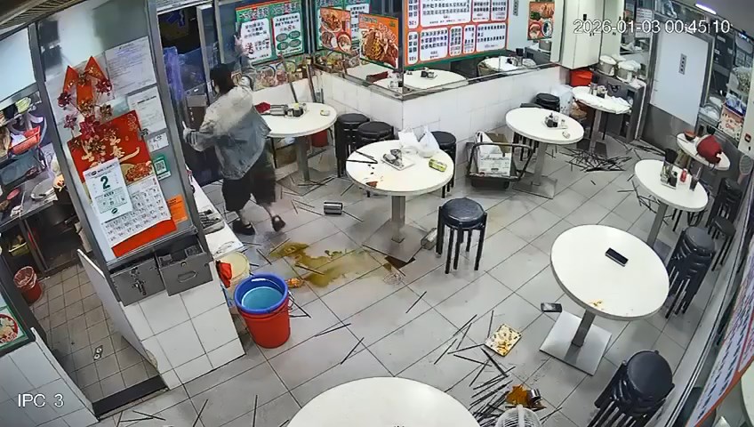 女子突然揮刀砍向警員盾牌。