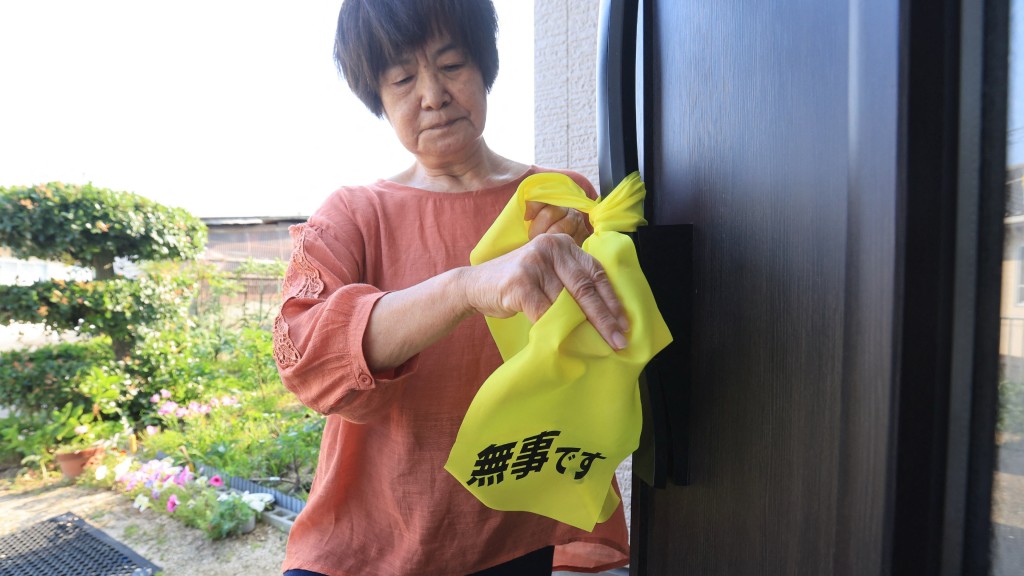 岡山縣民眾準備寫上「無事」的醒目黃布,一旦遇上天災可掛在門外報平安。 法新社 岡山縣民眾準備寫上「無事」的醒目黃布,一旦遇上天災可掛在門外報平安。 法新社
