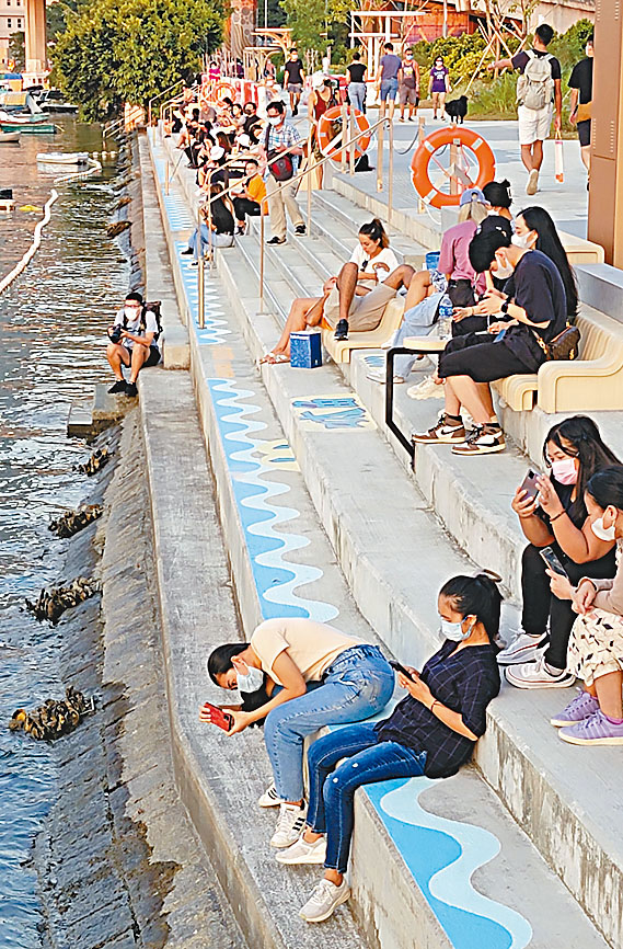 活力避風塘主題區的海岸堤階開放後吸引大量市民前來看海,幾乎「座無虛席」。