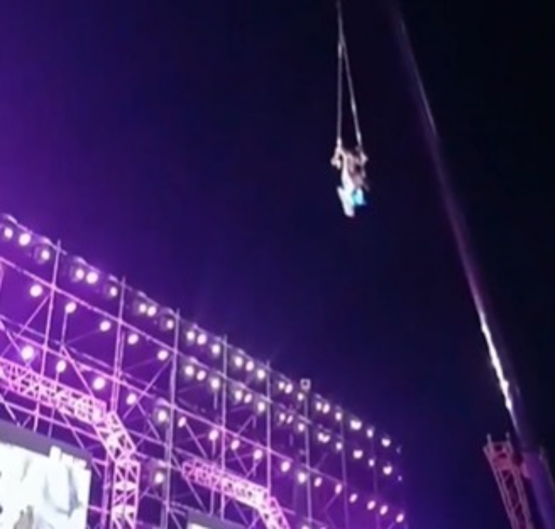 兩名男女演員在高空抓住吊環玩雜技。