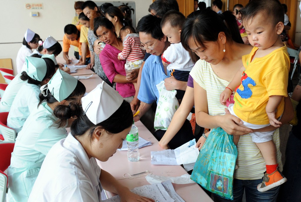 家長帶著孩子在南京市兒童醫院用會議廳改成的專病門診區登記接受檢查。 新華社發