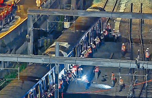 工程人員合力將列車推回月台。