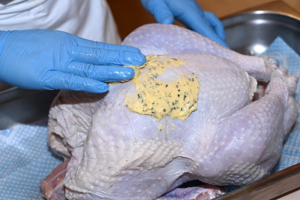 9. 將牛油分別塗抹在火雞皮與雞肉之間，然後再均勻地塗抹在火雞表面。