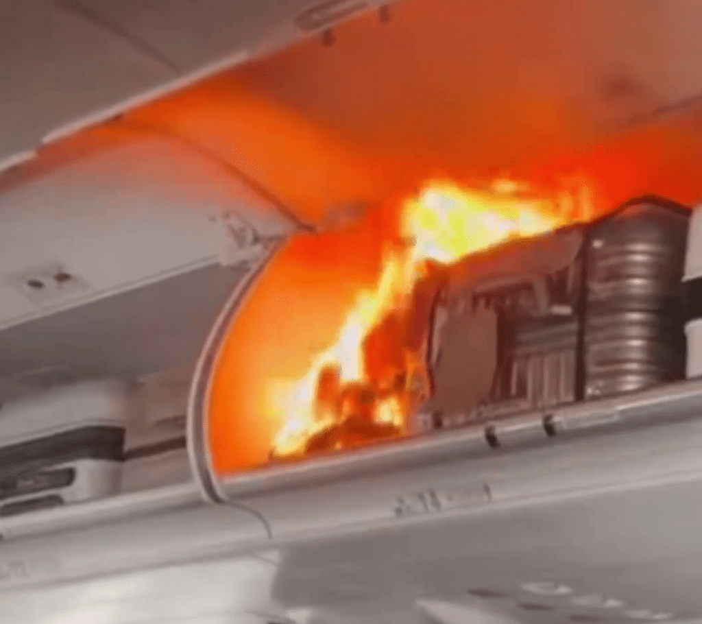 飛機客艙行李架上出現了明火。 飛機客艙行李架上出現了明火。