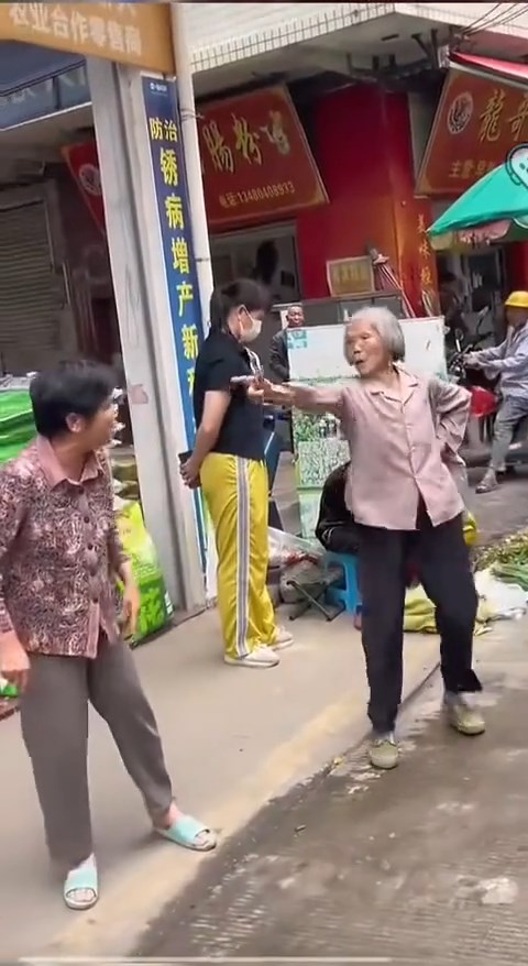 白发老妇与邻人起争执时，连续6次摆出“开枪”手势。抖音@月亮好物分享