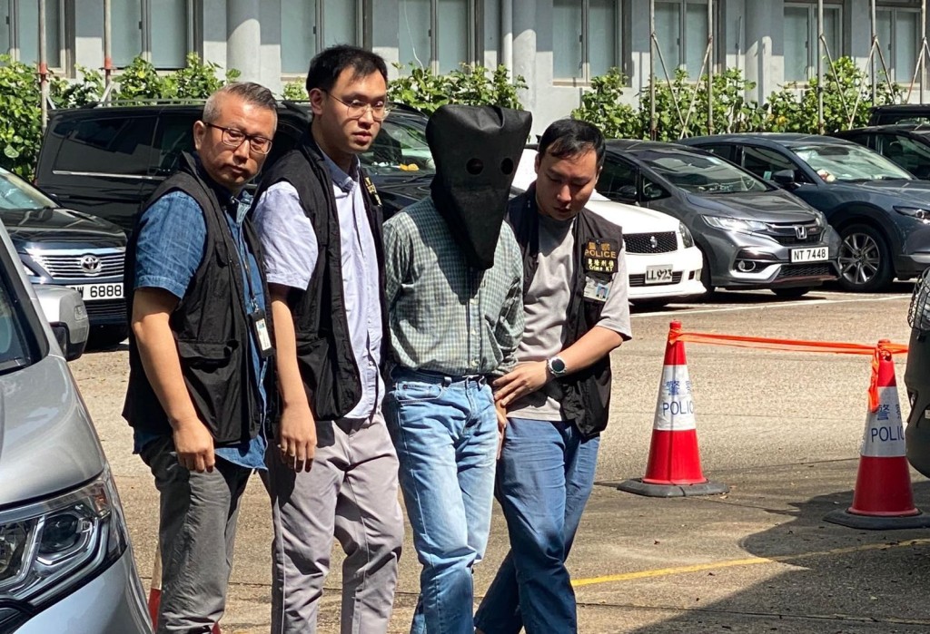 疑犯被黑布蒙頭帶署扣查。