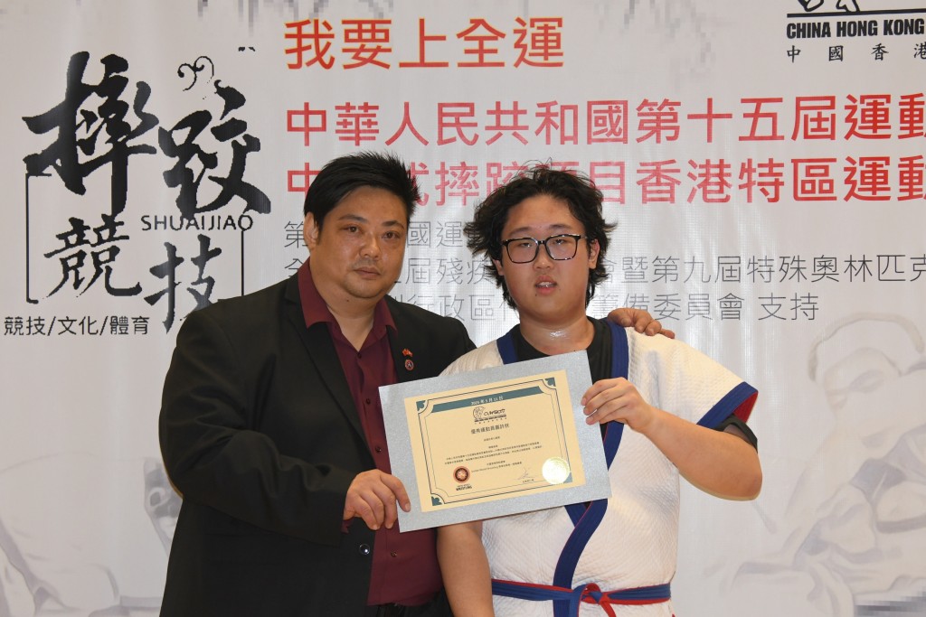 中國香港摔跤總會主席何仁傑(何sir)頒發獎狀予高伯魚。圖片由中國香港摔跤總會提供
