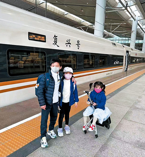 坐火车去西安时，三兄妹各自拿行李，霍中曦更搭着妹妹霍中妍的膊头，展示大哥哥风范。