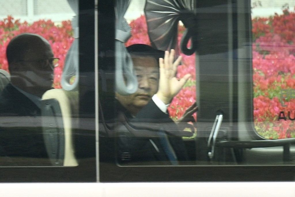 夏宝龙向在场传媒挥手。中联办主任郑雁雄（左）亦在车上。卢江球摄