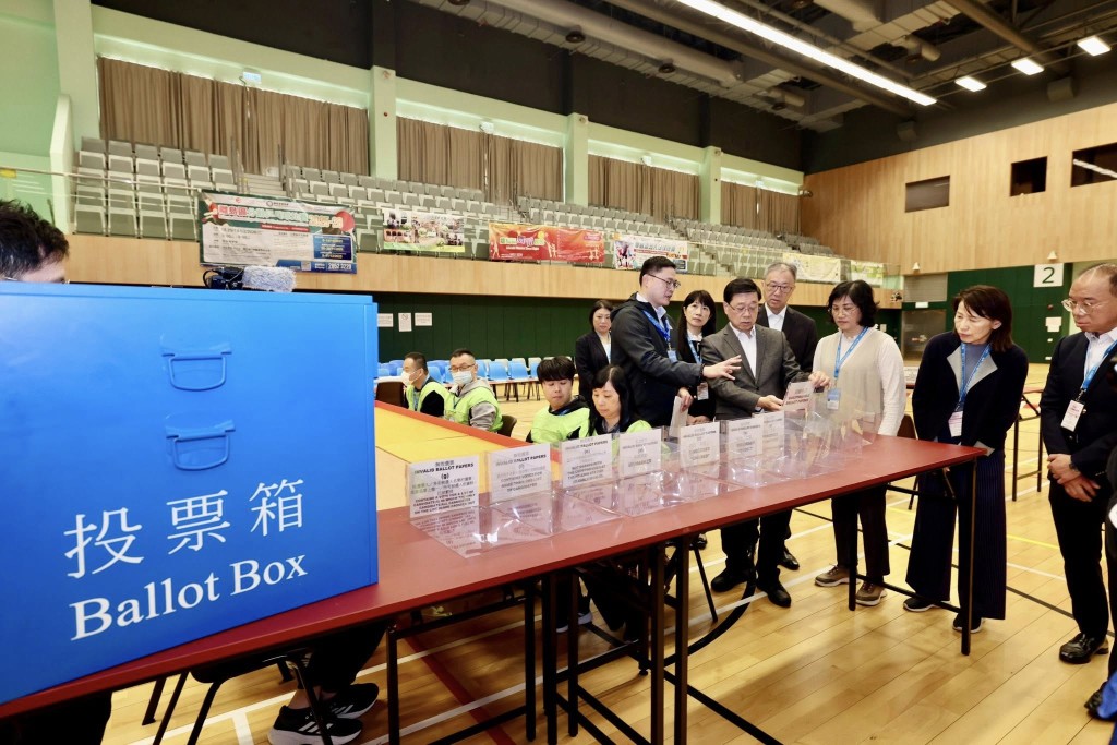 李家超(右四)到訪東涌文東路體育館的一般投票站。李家超FB圖片 李家超(右四)到訪東涌文東路體育館的一般投票站。李家超FB圖片