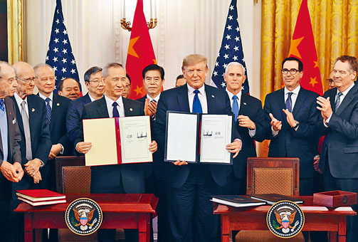 特朗普与刘鹤展示协议签名。