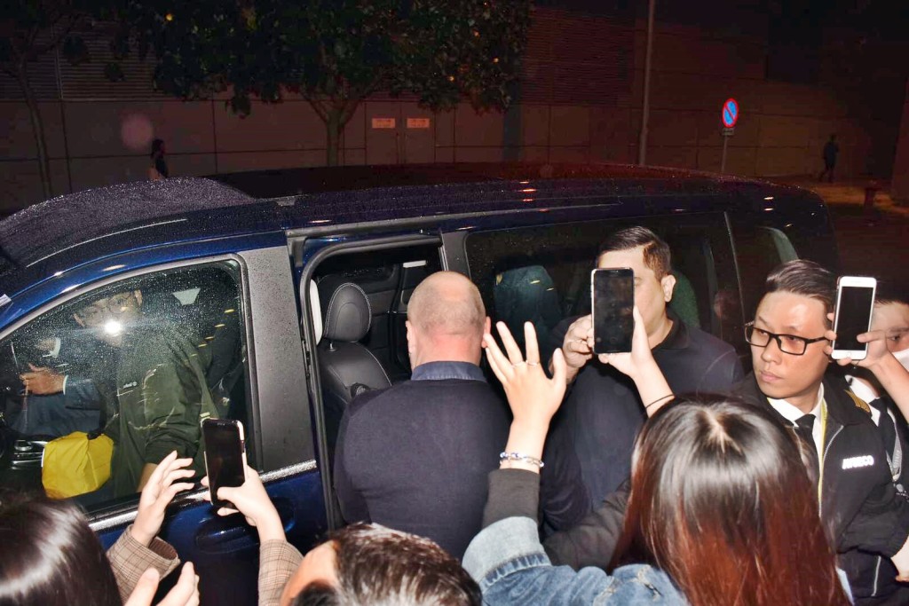 戴着口罩的张艺兴已上车，向车外粉丝挥手。