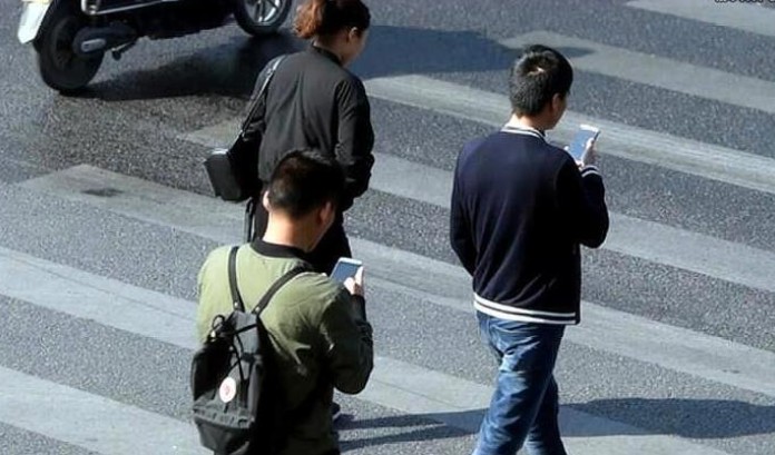 現時不少過馬路仍在看手機。網圖