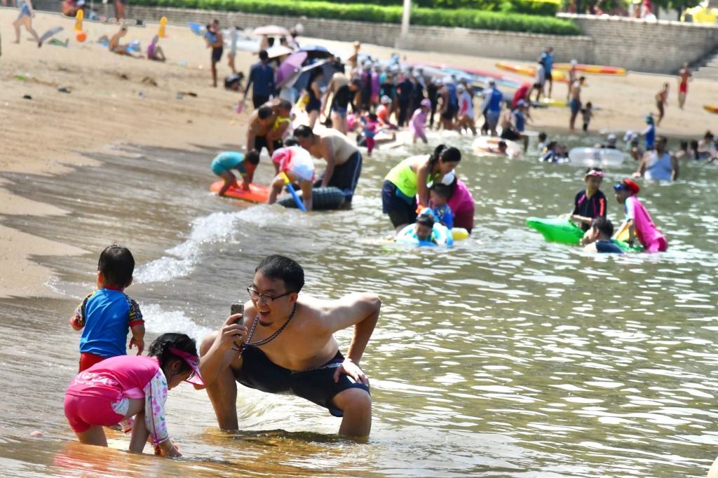 大批市民涌去沙滩玩水消暑降温。
