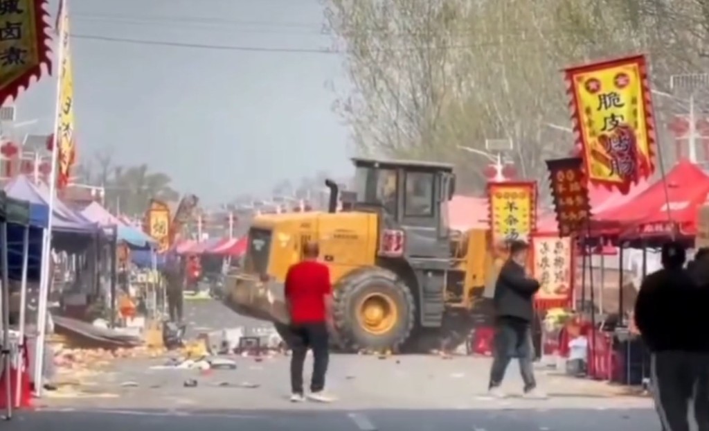 重型铲泥车冲入市集人群，造成多人倒地。Ｘ