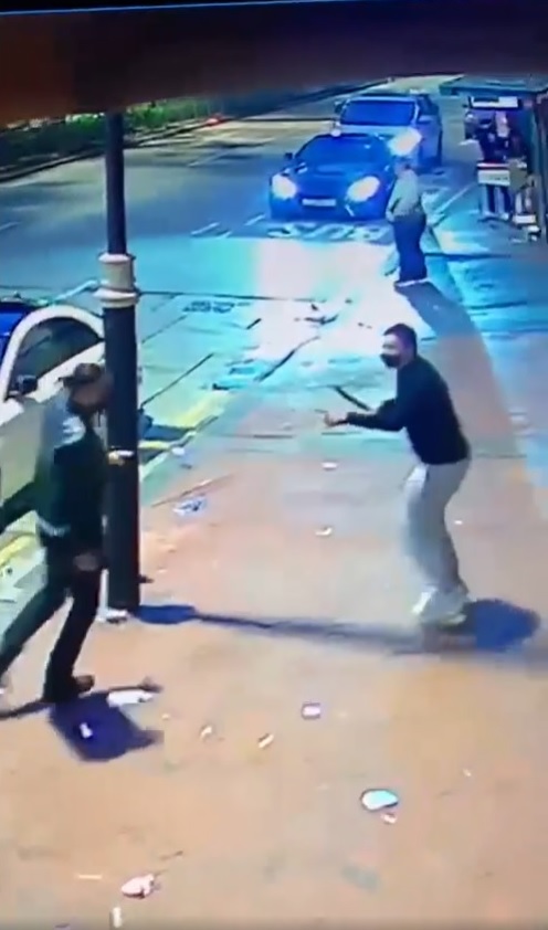 其中一名黑衫男与马尾男在漆咸道南街头互相持刀对峙。(影片截图)