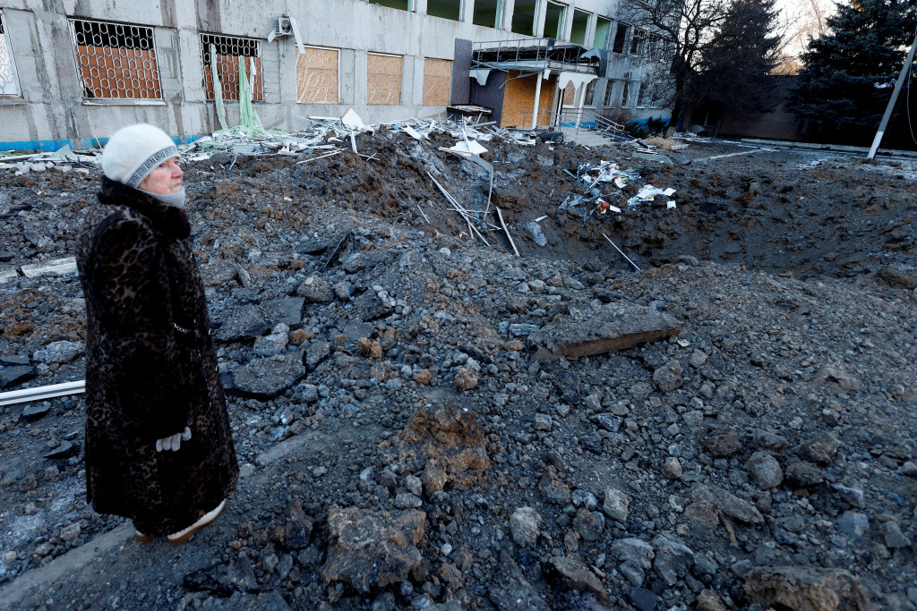 在乌克兰克拉马托尔斯克市，有人在被俄军袭击留下的弹坑前留影。路透社