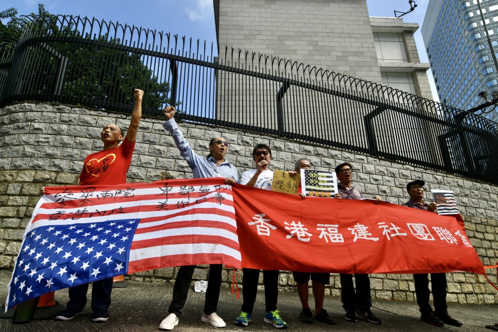 香港福建社团联会成员在美国国旗上写上「参众两院 卑鄙无耻 香港内政 关你乜事」。卢江球摄