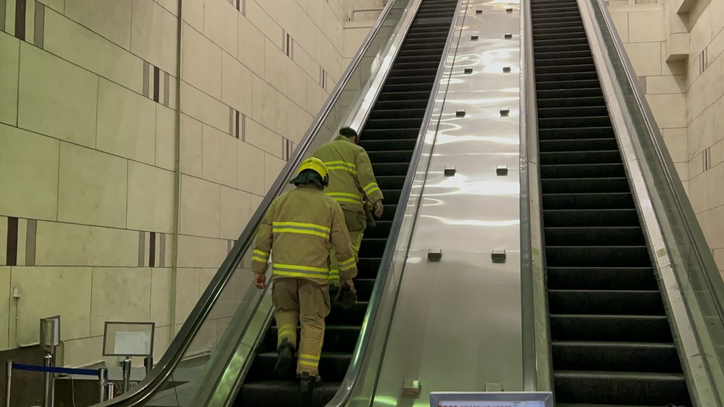 消防員沿故障的扶手電梯步上麥當勞視察火警情況。(資料圖片)