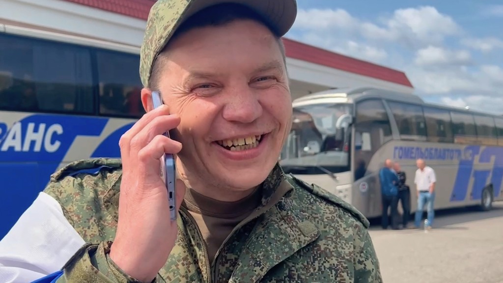 一名獲釋俄兵抵抵達白俄後，開心與家人通電話。 美聯社