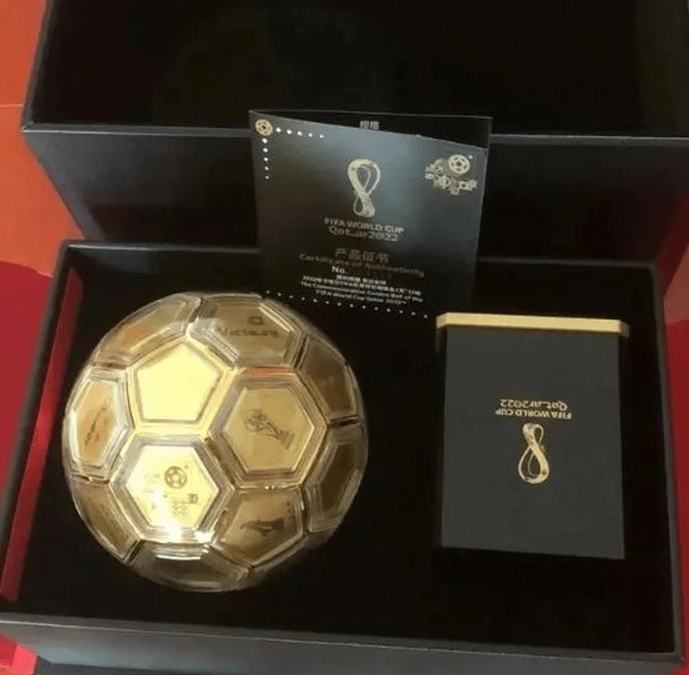2022年卡塔尔FIFA世界杯至尊金球，属于限量定制款，底座是有美斯的亲笔签名，特许首发价为RMB 99800元。网图