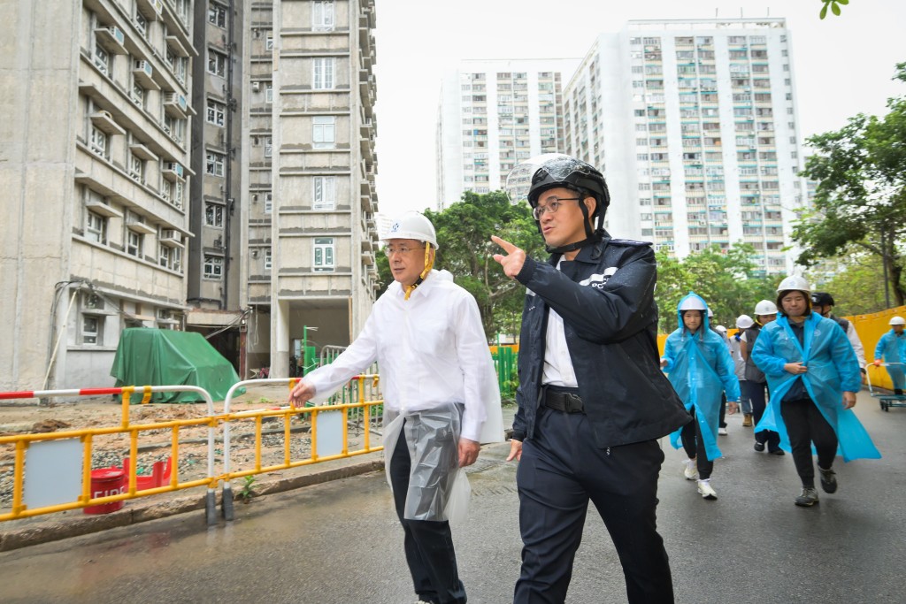 政務司副司長卓永興（左）在大埔警區指揮官江永祥（右）陪同下視察宏福苑。