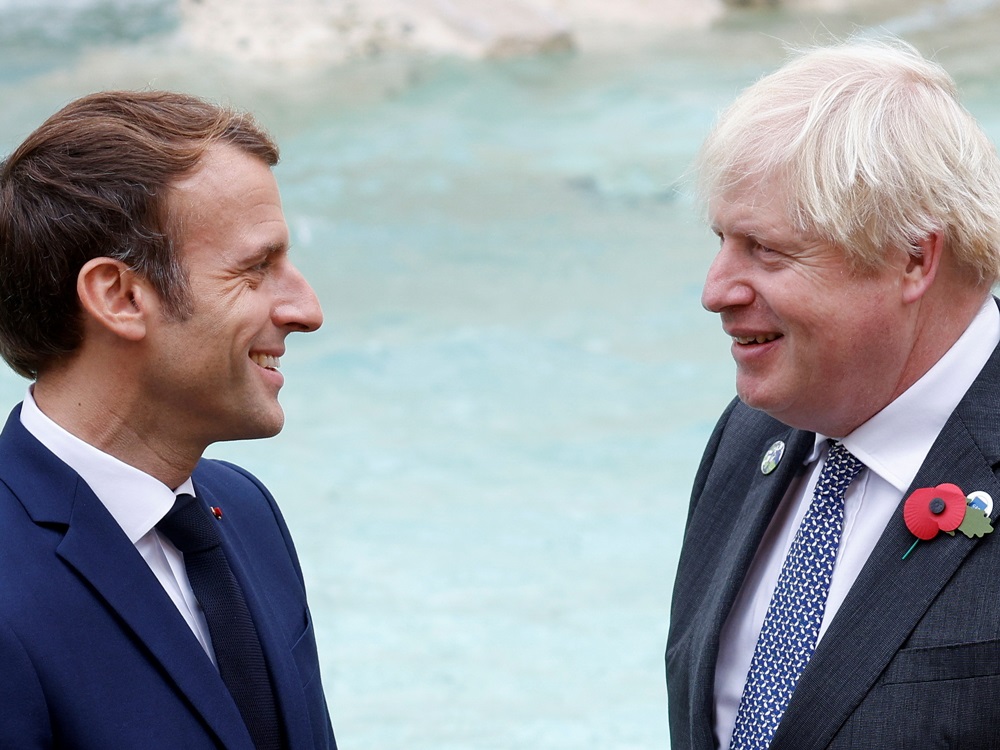 马克龙与约翰逊交流时，面露尴尬。路透社图片
