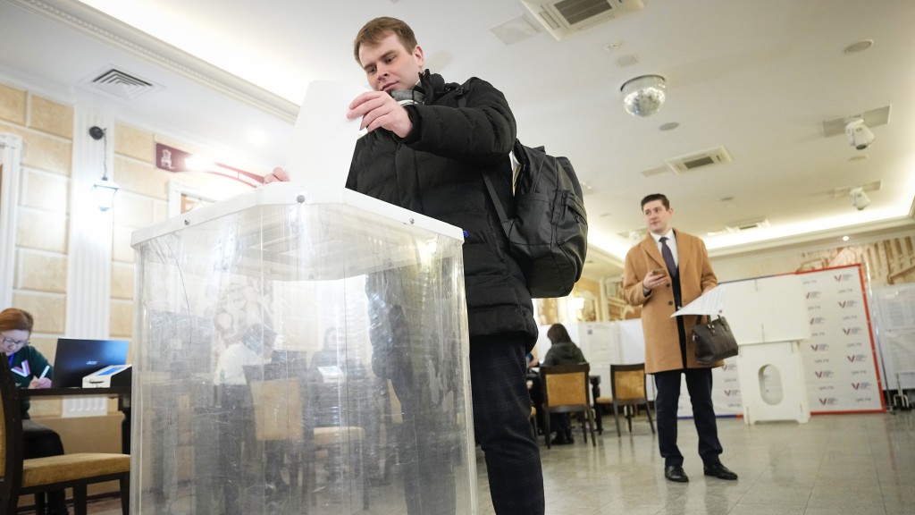 莫斯科一名男子將選票放入透明票箱。 美聯社