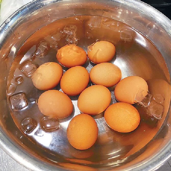   將半熟蛋撈起放入冰水內，用茶匙輕敲蛋殼。
