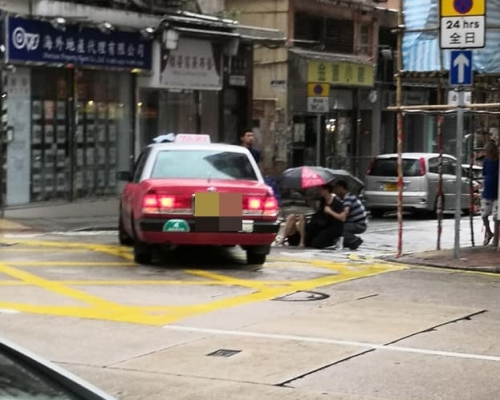有熱心途人為傷者撐傘擋雨。 香港突發事故報料區FB/網民Silas Siu圖