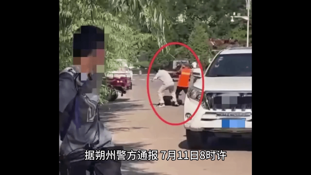 網傳影片顯示，馬路中心，一名疑似身著環衛工服裝的人持械向倒地的男子施暴。