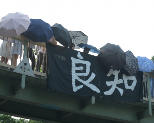 有學生在天橋上掛上「良知」的橫額。