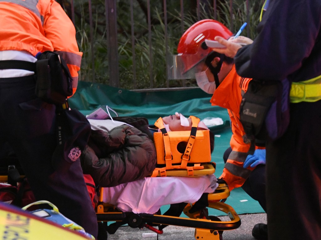 部分伤者须戴上颈箍固定伤势，由救护员经担架床送上救护车送院。(伍明辉摄)