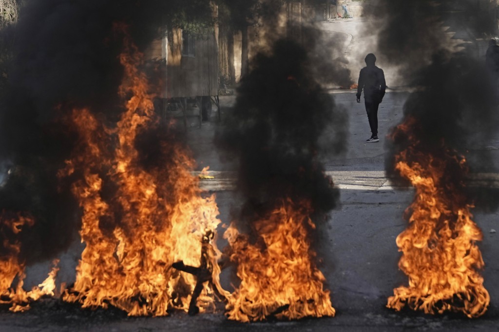 巴勒斯坦示威者焚烧轮胎，抗议以色列军队对约旦河西岸城市伯利恒的 Aida 难民营发动致命袭击。AP