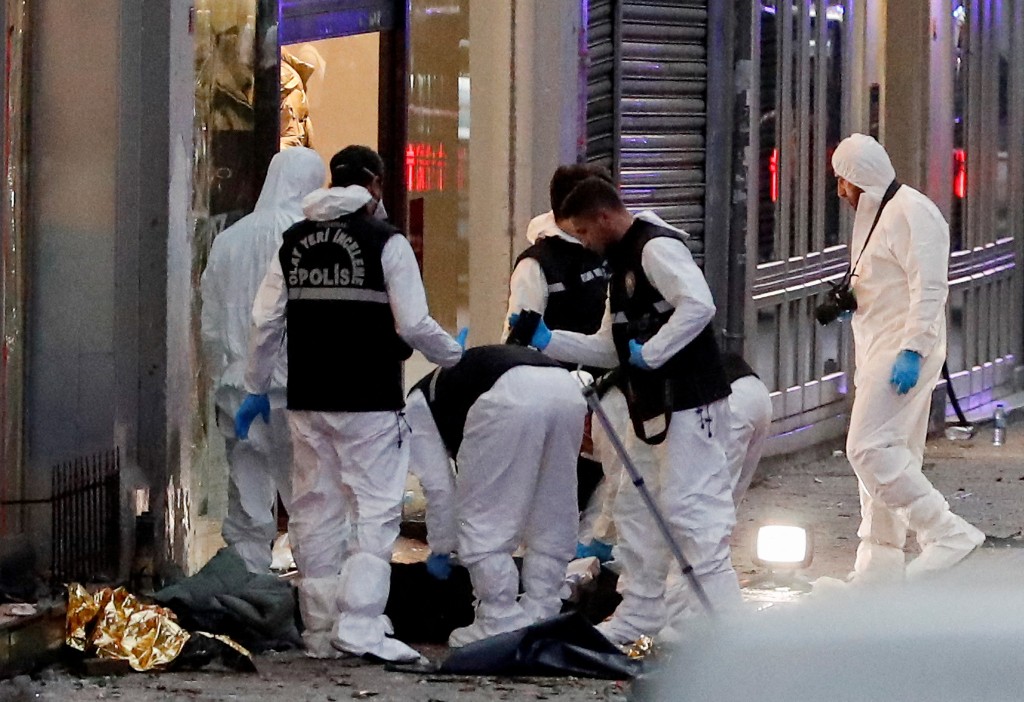 土耳其伊斯坦堡繁忙的独立大街发生爆炸后，警察在身份不明的人的尸体附近搜证。路透