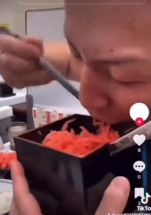 影片中的男子拿起共用容器中的红生姜，做出像是「扒饭」一样的动作。网片截图