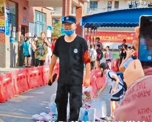 ■小學門外有保安要求學生放下鮮花和禮物才能入校。