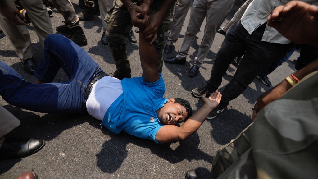 印度民众到国会外抗议曼尼普尔暴乱，有示威者被警员控制。 美联社