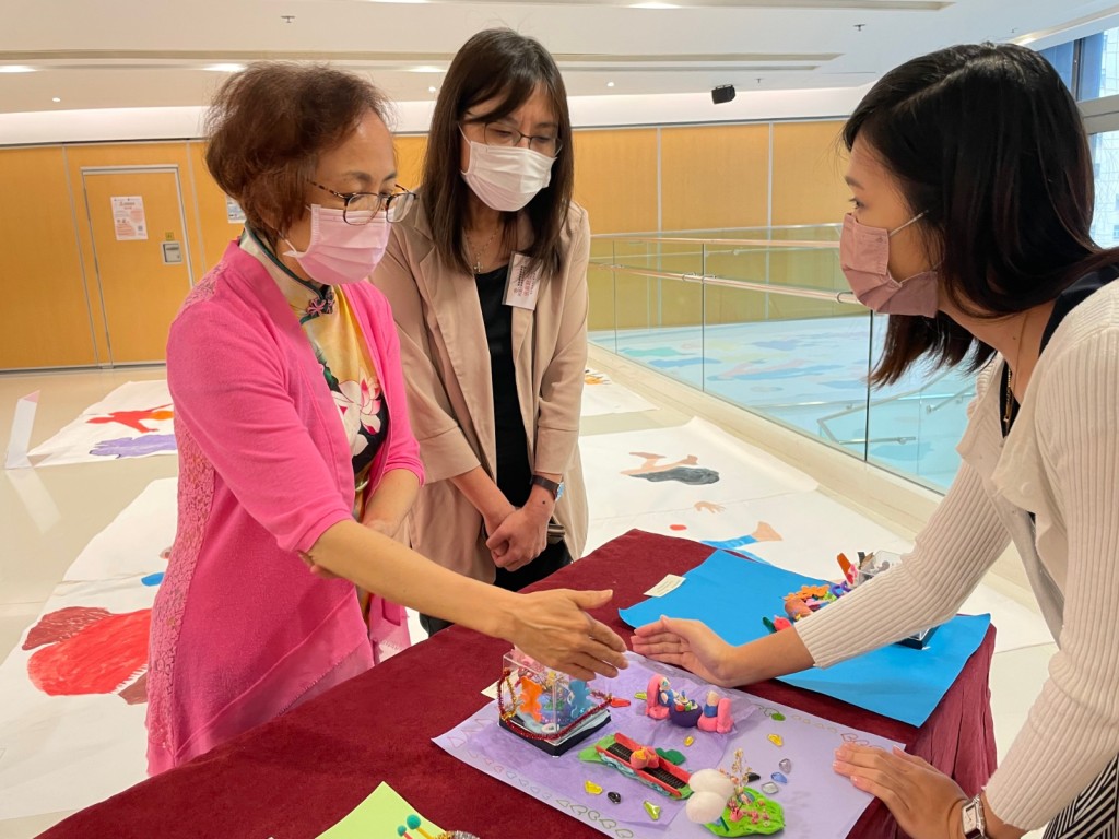 港大榮休教授陳麗雲女士及鄰舍輔導會副總幹事張嘉懿欣賞由來自重組家庭親子共同製作的藝術作品，並了解背後的故事。大會提供