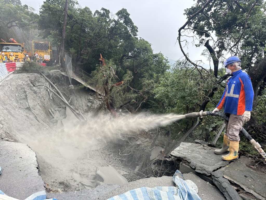 石澳道沿路山泥倾泻及路陷，道路封闭，石澳村、鹤咀村及大浪湾村与外界断绝接触，俨如荒岛。工人向坍塌山坡喷浆。资料图片