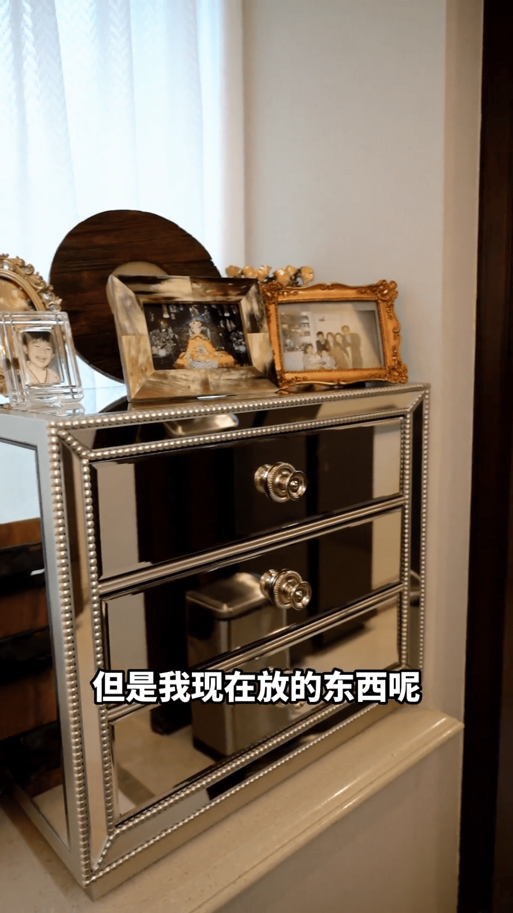 戴蕴慧家中有个金属抽屉柜，上方摆满家庭照。