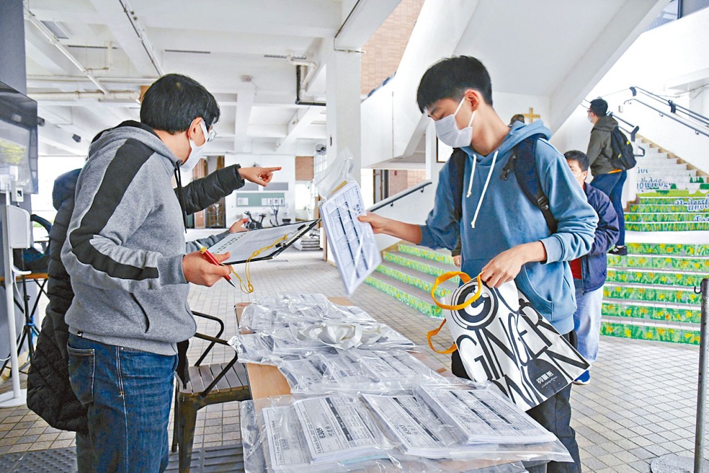 聖若瑟英文中學首次網上實時進行中六模擬考試，學生返校領取各科答題紙的「考試物資包」。