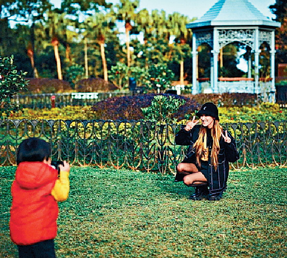 ■陳凱琳在公園除罩讓兒子拍照。