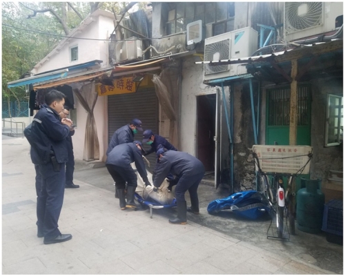 仵工將老翁遺體運走。林思明攝