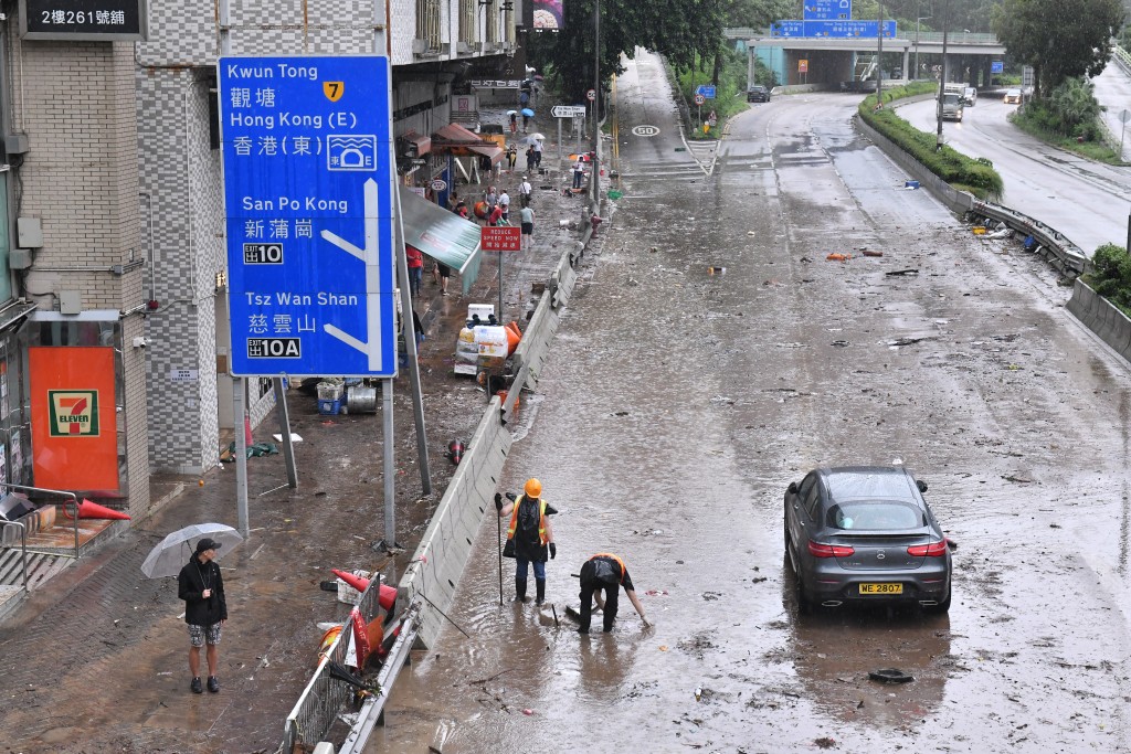 路面水浸下仍有市民外出或上班工作。陈极彰摄