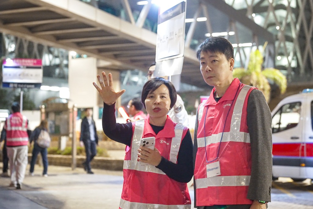 港鐵公司昨日凌晨舉行大型聯合演習，港鐵代表向將軍澳區「社區聯合應變組」及相關政府部門代表介紹調景嶺站港鐵免費接駁巴士的新安排，港鐵公司副總監—車務營運及本地鐵路李婉玲（左）在場視察新安排的運作。